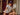 Woman wearing a white t-shirt with Club Recess logo and a blue cap sitting indoors.